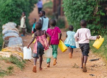Bambini che corrono con le taniche per l'acqua